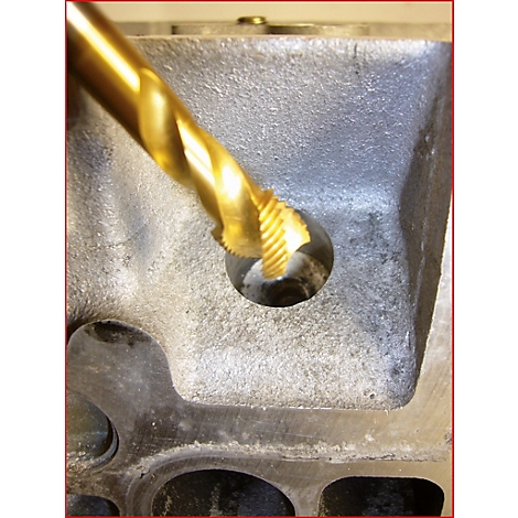 Nahaufnahme eines goldfarbenen Bohrers, der in ein Loch in einem grauen Metallblock bohrt.